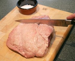 Marjorie has cut cross-hatches on the fat layer of the picanha, and is about to rub salt onto the meat (and particularly into the cuts). When cooking the meat, it's important not to pierce it -- in doing so, the juices will escape.