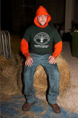 Sitting on a small bale of hay.