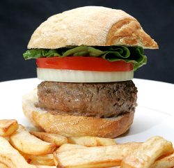 Marjorie made me this hamburger last night from our Scottish | Kobe beef, a Jack Hawkins tomato from Waitrose, a sweet onion, and a freshly-baked roll. It was too good to eat without first taking a photograph. Having snapped the shot, I then sat on the couch and ate it while watching TV: it was super moist, and incredibly delicious.